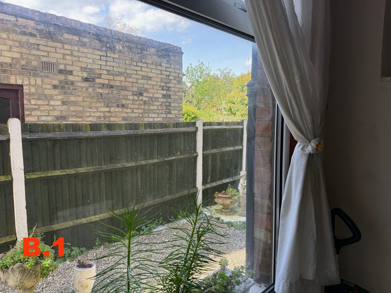 Second view from window B at [REDACTED], looking onto the side wall of No. 89 over the fence